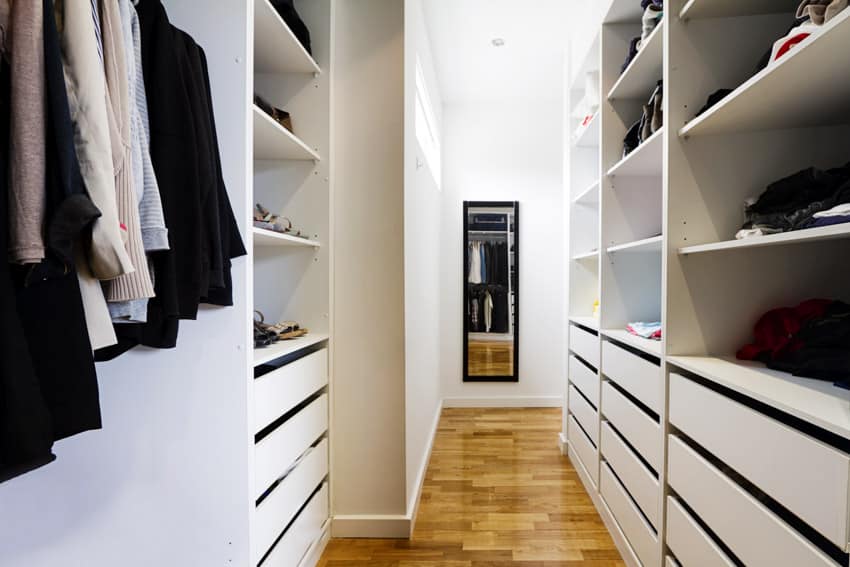 Walk-in closet with painted melamine wood shelves, drawers, and mirror