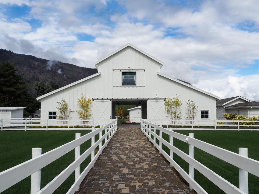 White barn with paved walkway and windows