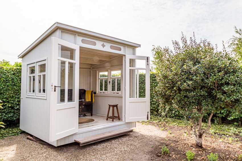 White outdoor shed with windows, door, and angled roof for backyards