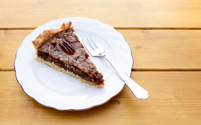 Wood surface with pecan pie and dessert fork
