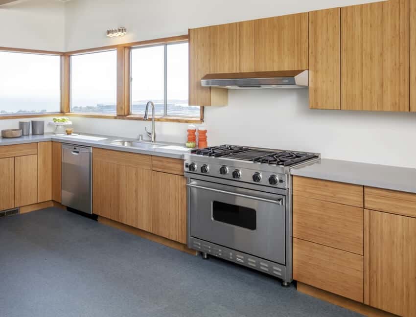 Wooden kitchen interior with grade b teak cabinets, glass windows with sea view and stainless steel appliances