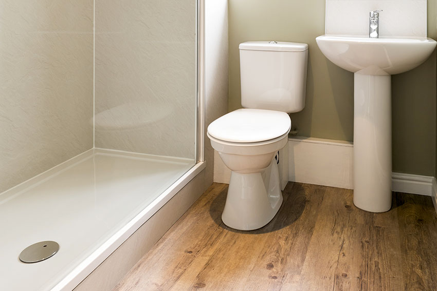 Bathroom toilet with frameless glass shower and ceramic vanity sink