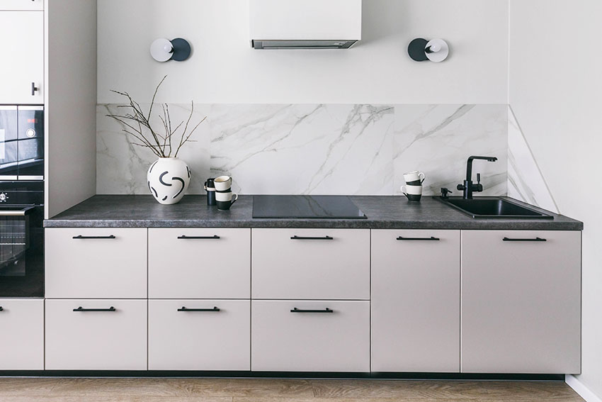 Clean modern kitchen with white cabinets black granite countertop quartz slab backsplash electric stove