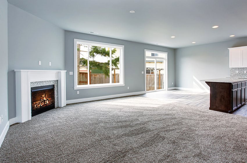 Empty living room with nylon carpet fireplace gray paint recessed lights