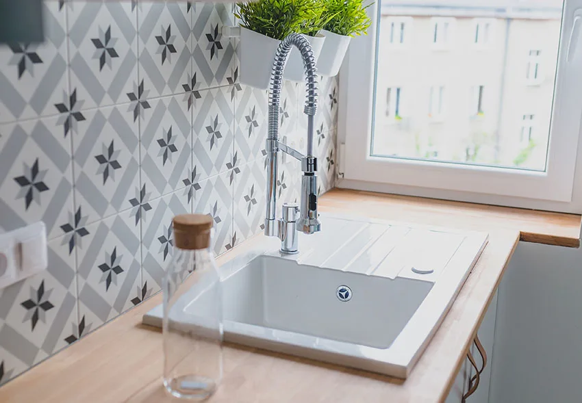 Kitchen with touchless faucet spanish tile backsplash porcelain sink