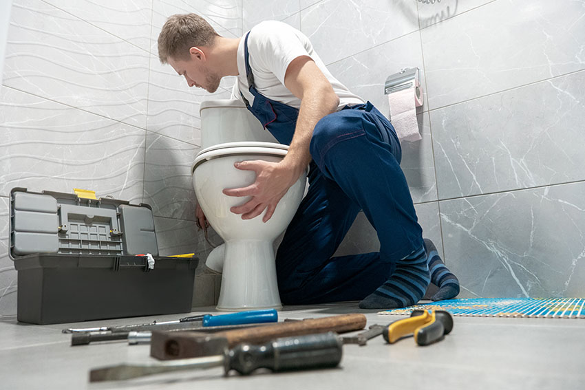 Man installing low flow toilet