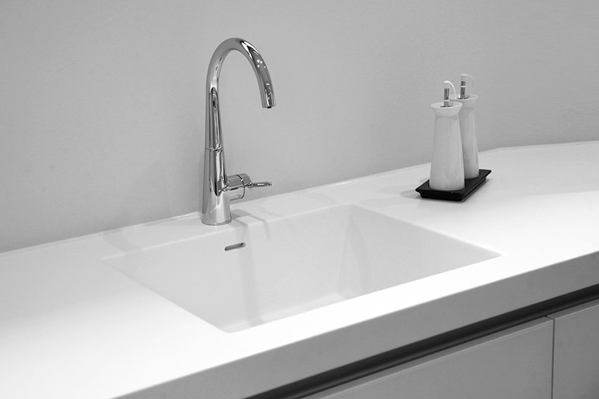 Solid surface sink with single handle faucet