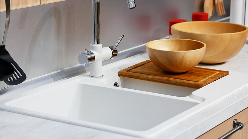 White acrylic kitchen sink with wooden bowls