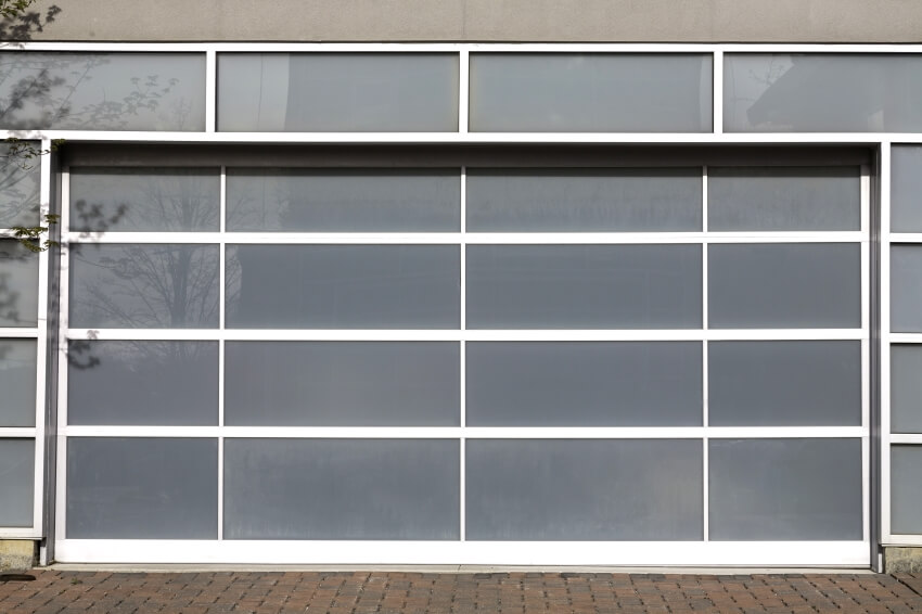 Access to a modern white garage door with frosted glass