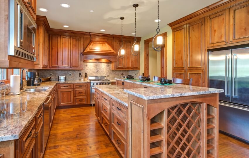 An arts and crafts kitchen with pendant lights, granite countertops, and wooden cabinets and floor