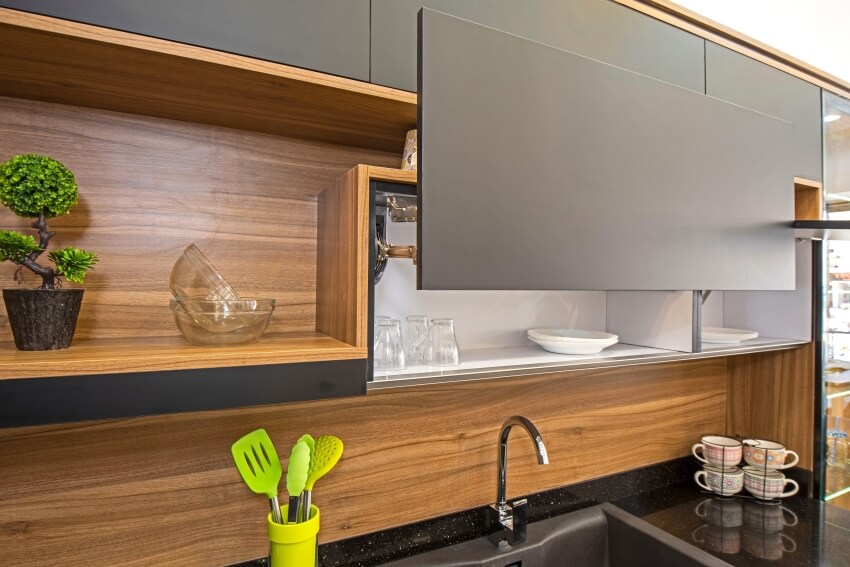 Apartment kitchen with modern cupboards, granite countertop, and wood plank backsplash