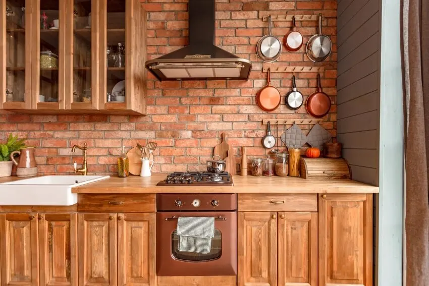 Arts and crafts design kitchen interior with brick backsplash and wooden cabinets