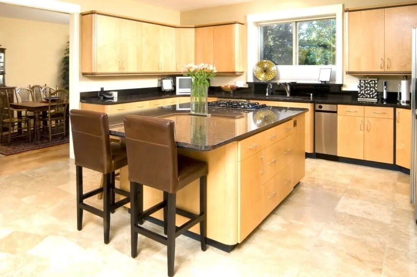 Baltic birch cabinets, and large island with chairs and cooktop in a modern kitchen