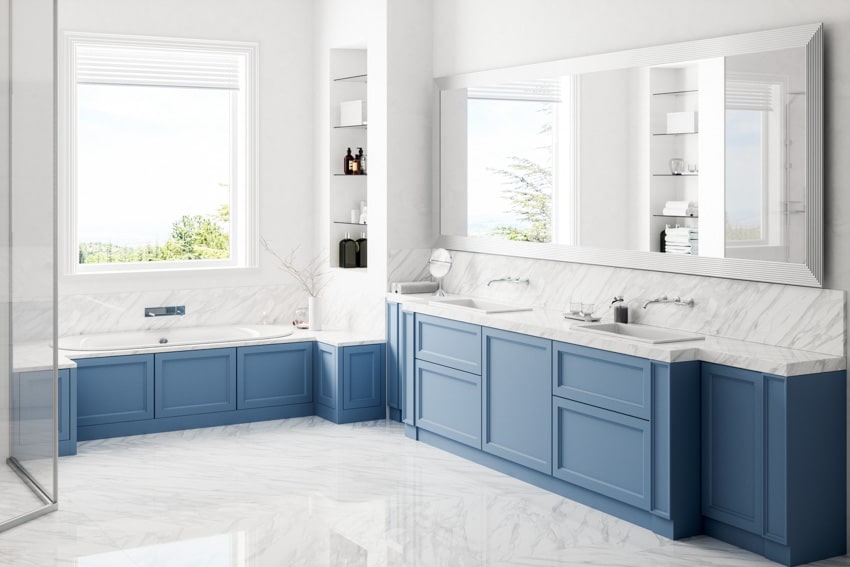 Bathroom with Carrara marble backsplash for vanity countertop, mirror, sink, blue cabinets, and window