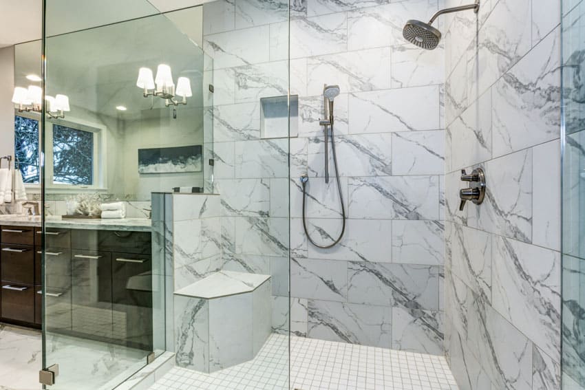 Bathroom with Carrara marble tile wall, shower, vanity area, mirror, countertop, and drawers