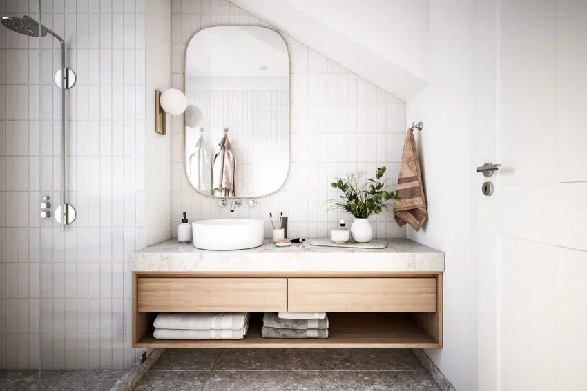 Bathroom with vertical tiles, floating shelves and oblong mirror with basin
