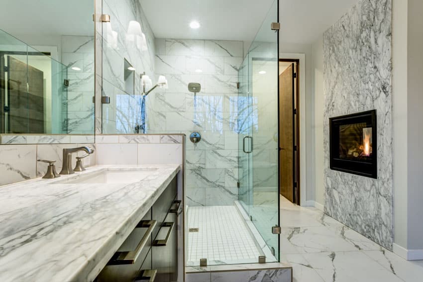 Bathroom with glass shower enclosure, marble tiles and gas fireplace
