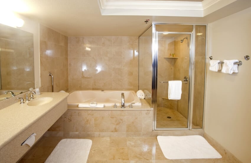 Bathroom with glass shower, wall-mounted towel racks and travertine floor