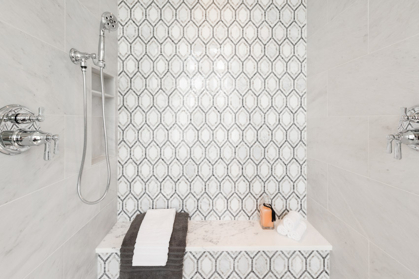 Bathroom with peel and stick picket tile backsplash, showerhead, and marble walls