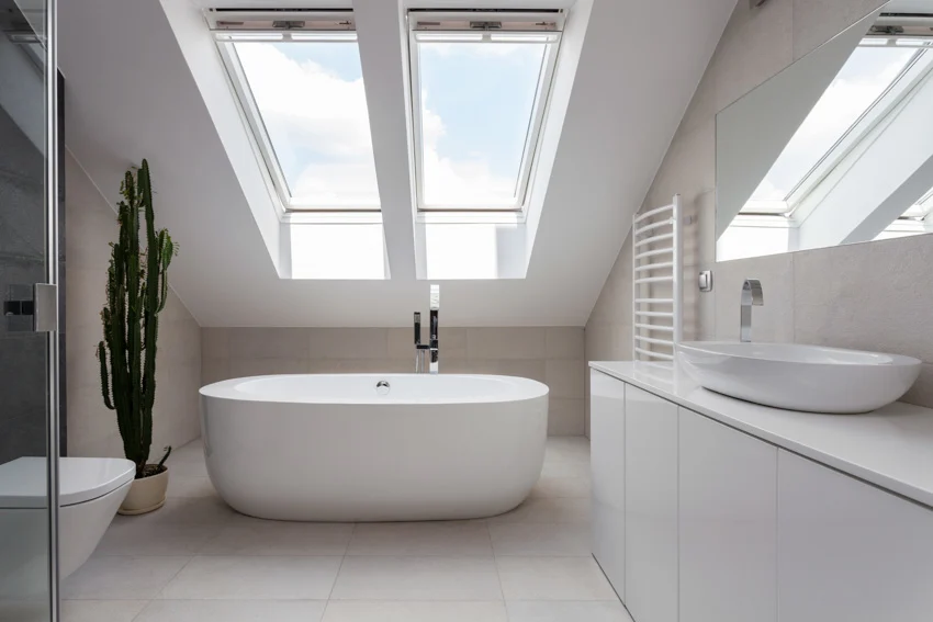 Bathroom with porcelain floor tile, tub, sink, mirror, cabinets and window