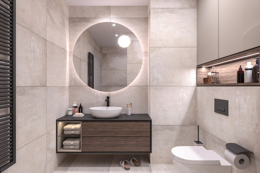 Bathroom with unglazed porcelain tile wall, mirror, countertop, sink, and toilet