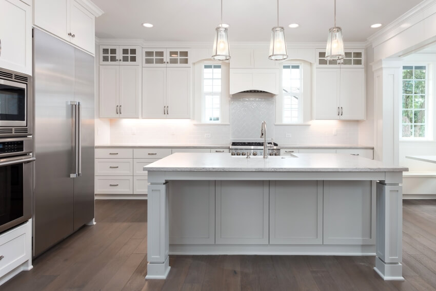Beautiful kitchen with island, pendant lights, ceiling height cabinets, and hardwood floors