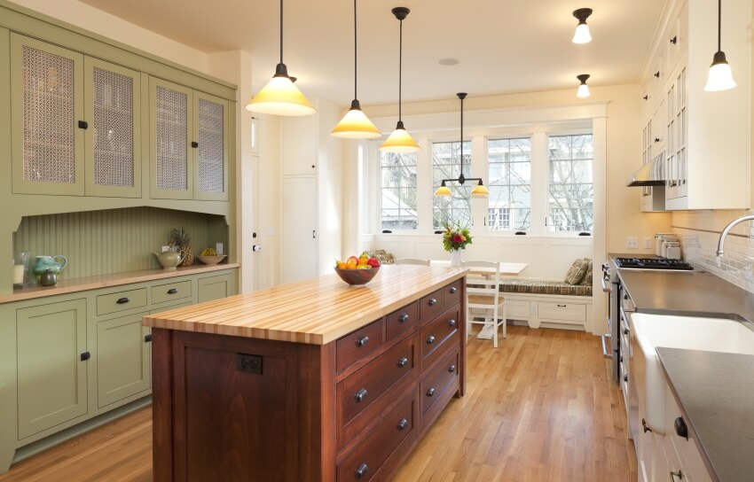 Beautiful kitchen with large island, a bay window sitting area, and green cabinets