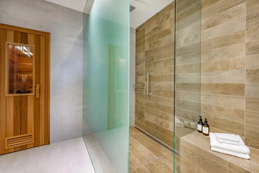 Shower are with slate panels, sauna door and glass walls