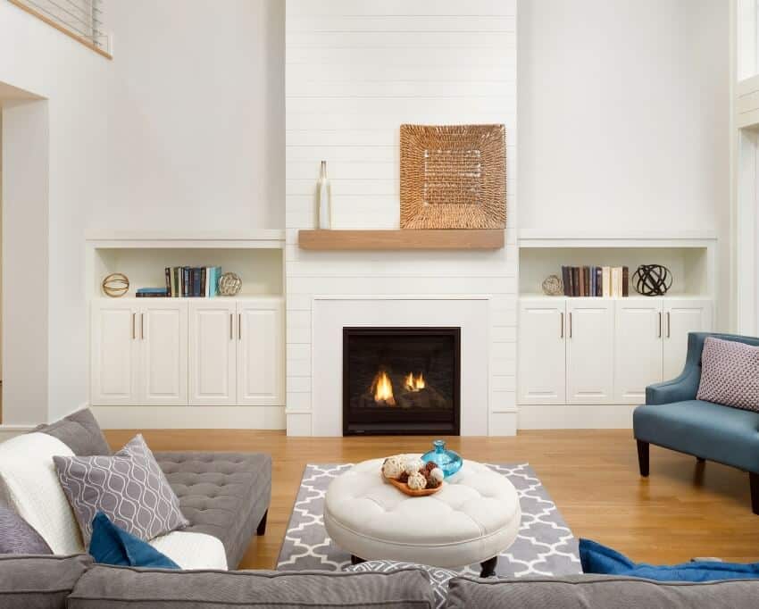 A beautiful modern living room interior with shiplap accent wall on fireplace and hardwood floors in new luxury home