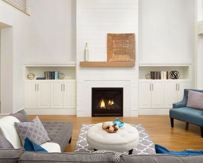 Room with shiplap accent on fireplace and hardwood floors 