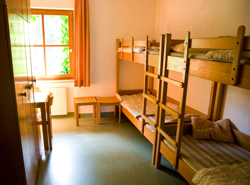 Bedroom with wood bedladder, window, mattress and curtain