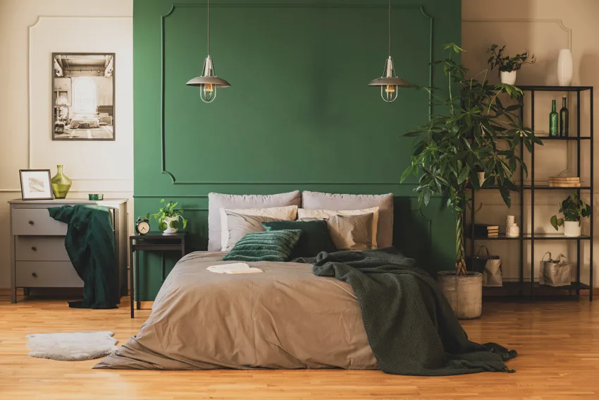 Bedroom with pendant lights, grey comforter, pillows, freestanding shelf and dresser