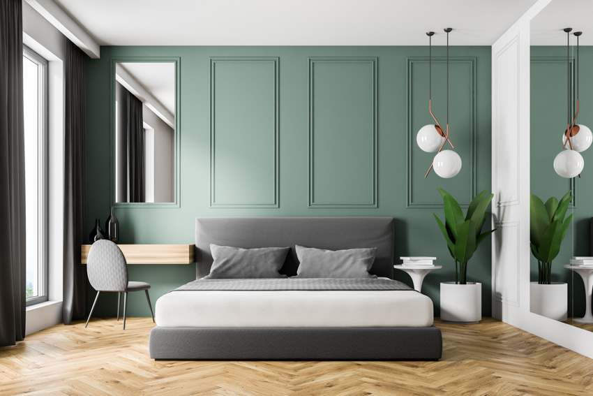 Green panel wall, wooden dresser and tall mirror in the bedroom
