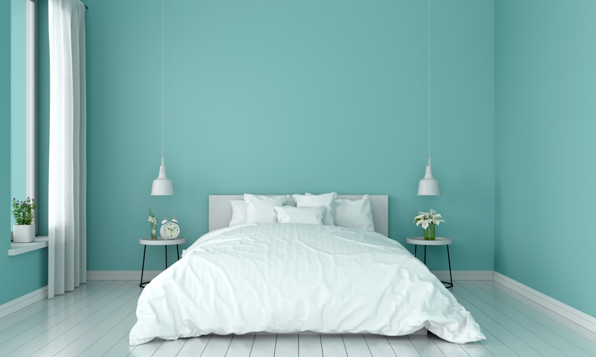 Seafoam green room with white wood plank floors and bed