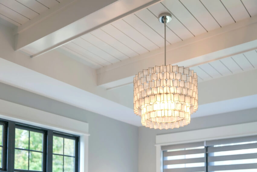 Black windows and nickel gap shiplap ceiling with a hanging pendant light
