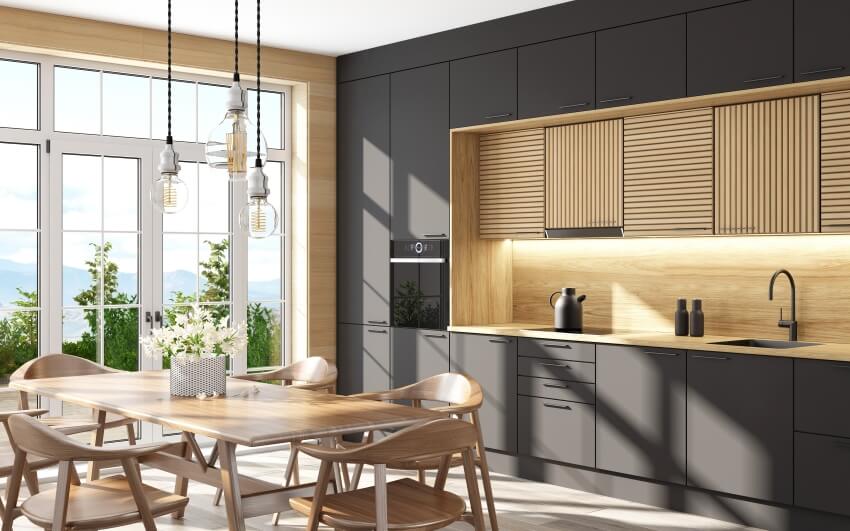 Kitchen with floor to ceiling gray cabineys, wood backsplash and white windows