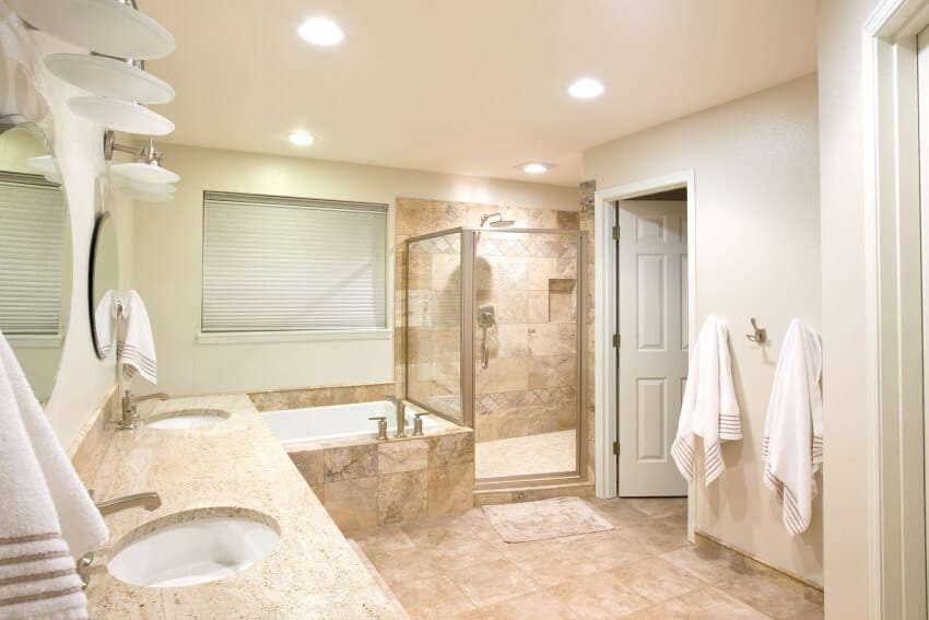 Bright master bathroom with travertine floor and granite countertops