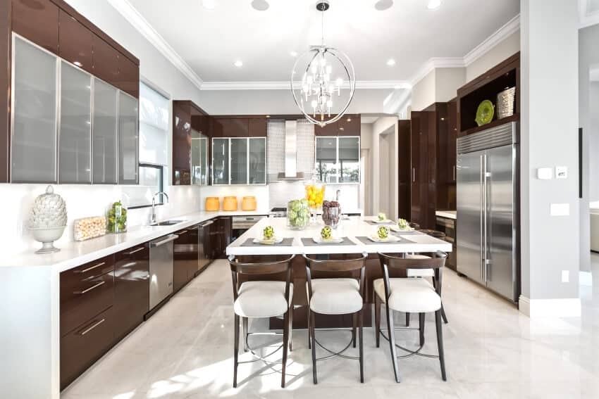 Bright modern kitchen with a counter height island, glossed cabinets, and granite flooring