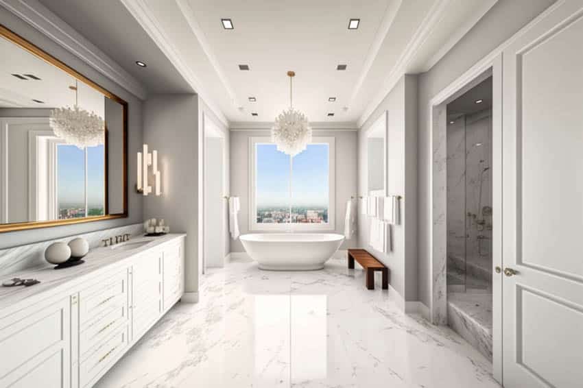 White bathroom with mirror with gold frame and freestanding bathtub