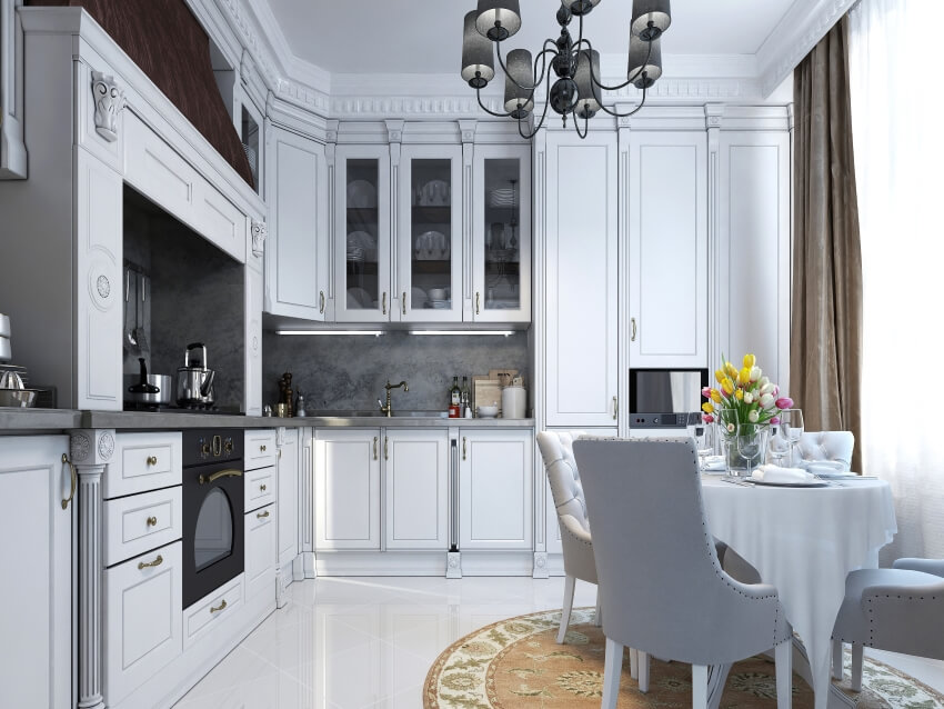 Classical style kitchen with chandelier, dining table, and ceiling height cabinets