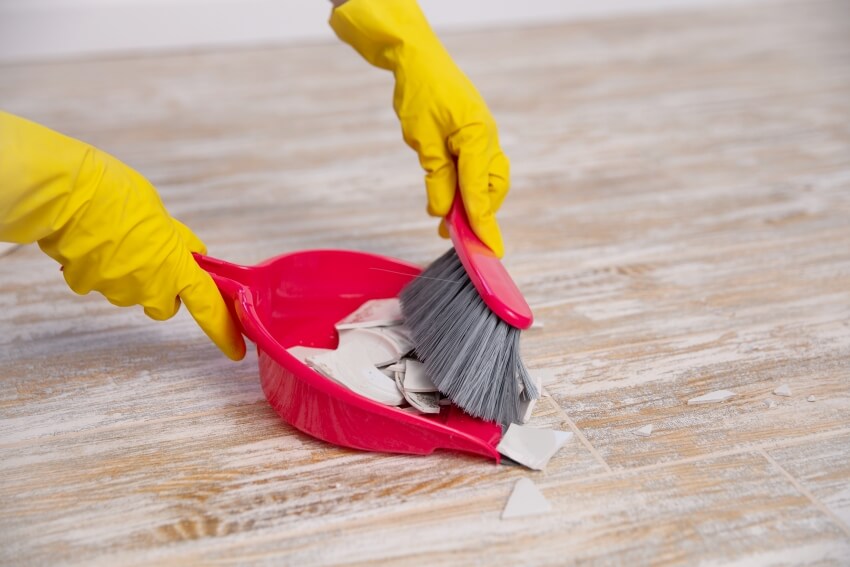 Cleaning up broken plate with a hand broom 