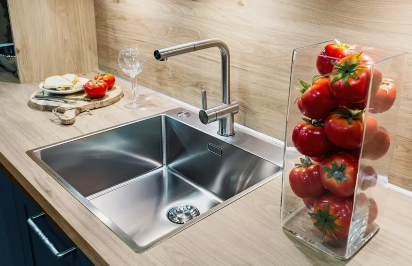 A close up of faucet and drop in sink in a modern luxury kitchen