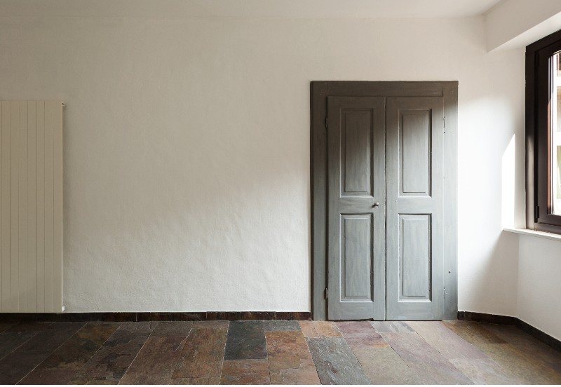 A closed door in a rustic house with faux stone tile flooring 