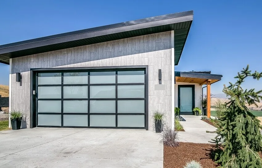 Contemporary modern home with concrete driveway and garage door with frosted glass