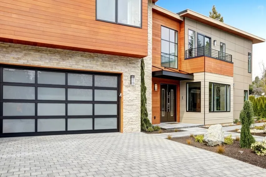Contemporary style home with wooden and stone facade and a frosted glass garage door