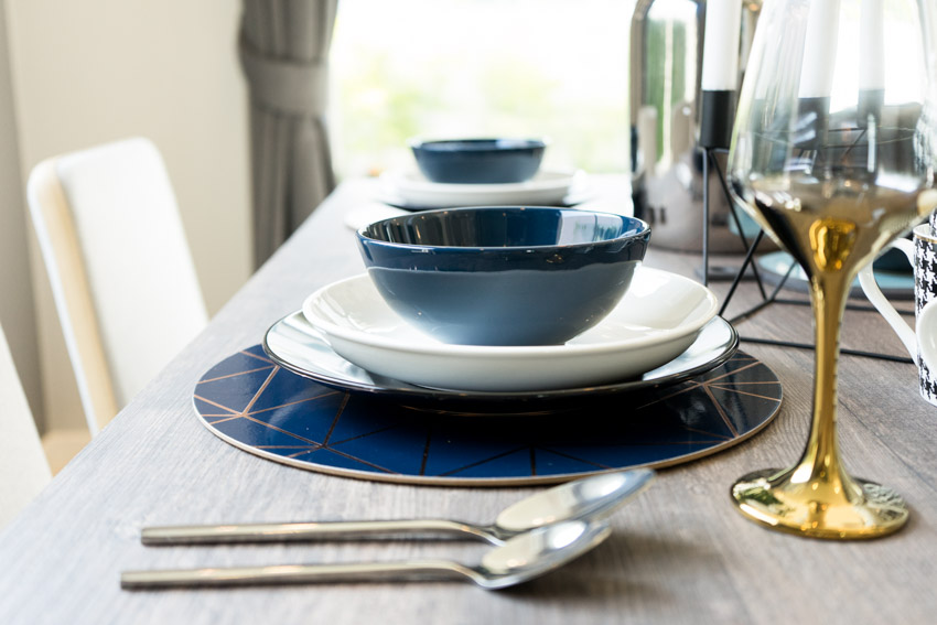 Dining table with spoons, plates, and bowls