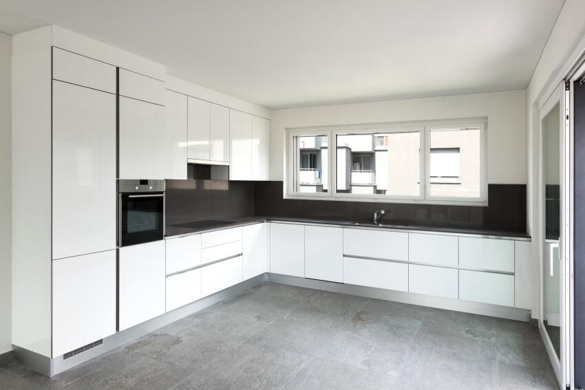 Empty kitchen with windows, dark gray backsplash and slate tiles