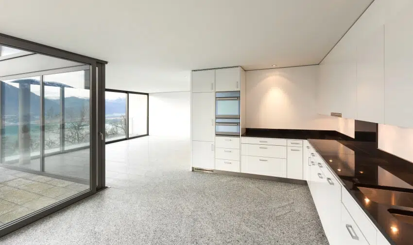 Empty apartment with panoramic windows and white undercounter cabinets 