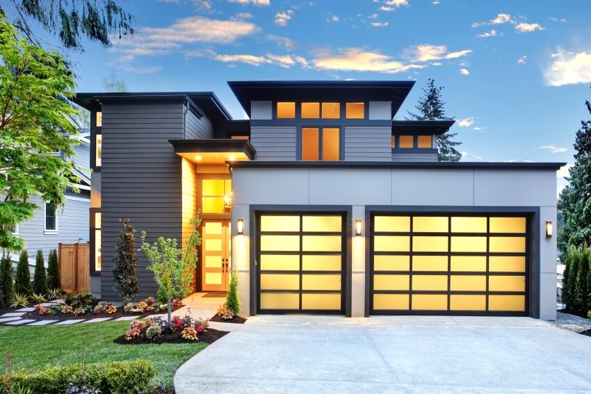 Exterior of contemporary home with two car frosted glass garage doors and shiplap siding