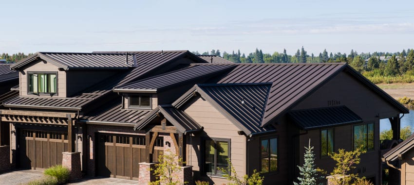 Exterior with metal roof, dormer, garage, and windows